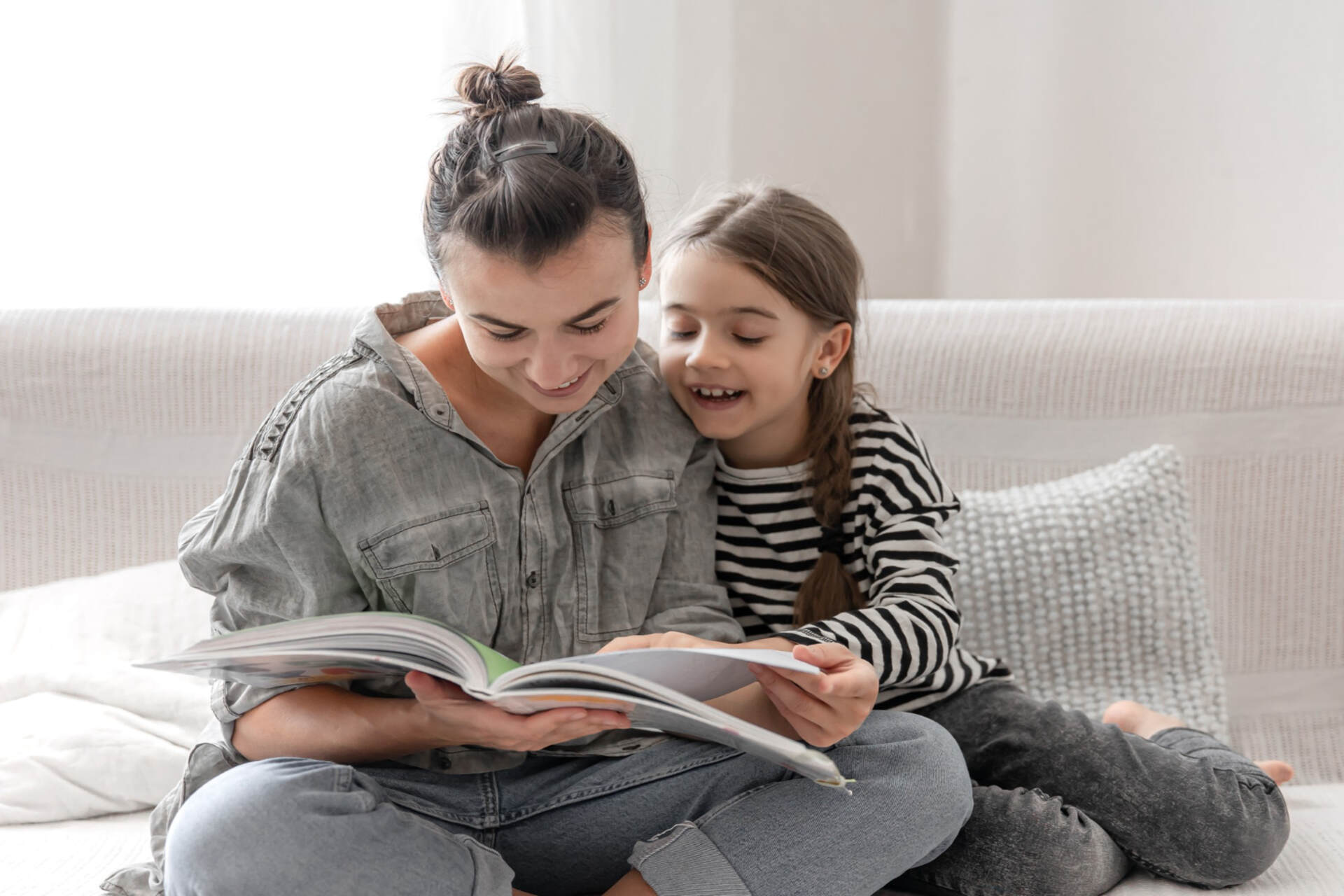 mom and daughter reading a book together while practicing reading comprehension strategies